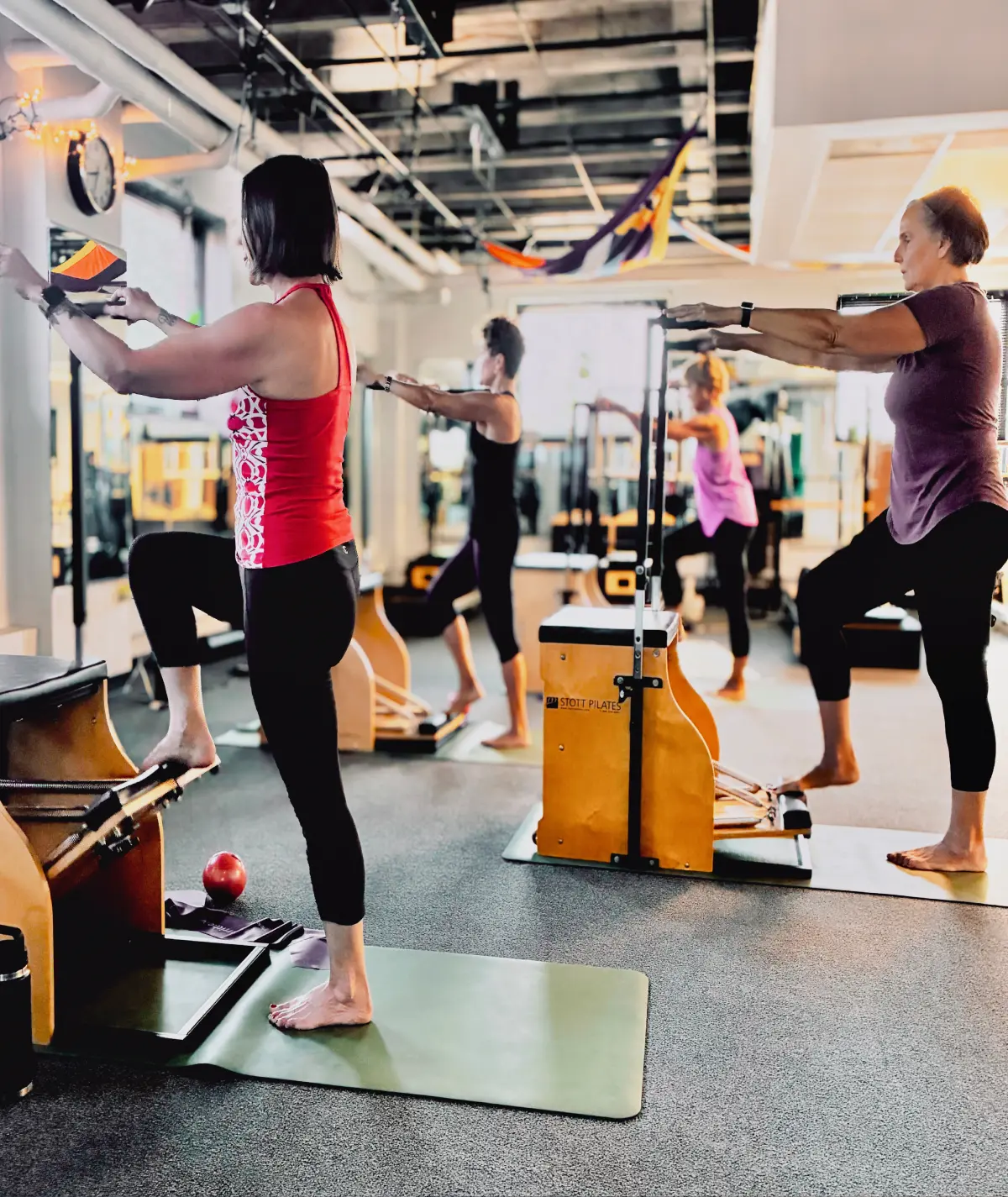 Women exercising on fitness equipment in gym.